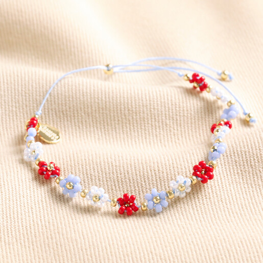 Estella Bartlett Red and Blue Daisy Chain Bracelet on Beige Surface
