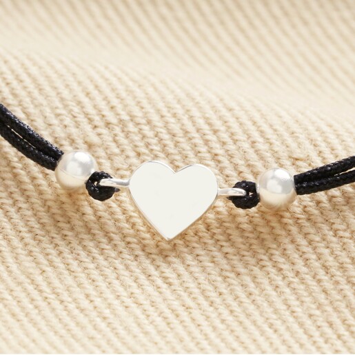Close Up of Sterling Silver Heart Cord Bracelet on Beige Fabric