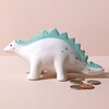 Dinosaur Money Box with coins outside against beige backdrop