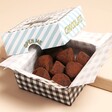 The Truffle Hunter Cocoa Dusted Milk Chocolate Truffles open showing truffles inside against neutral backdrop
