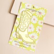 Designworks Ink Cowboy Boot Metal Bookmark on Packaging Card on Pink Surface