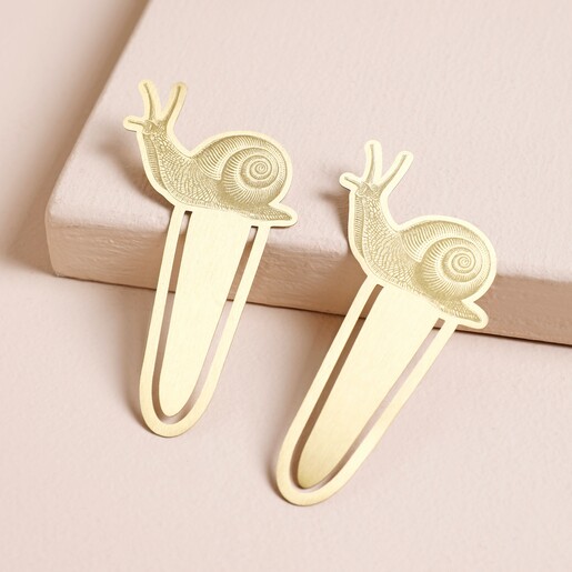 Designworks Ink Set of 2 Snail Metal Bookmarks laid on pink surface