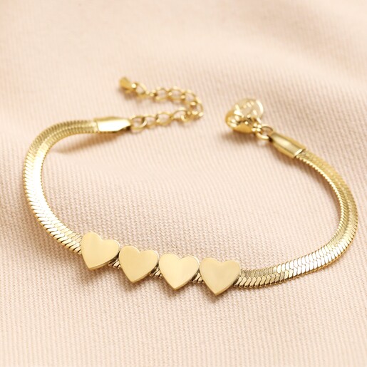 Gold Stainless Steel Four Heart Charm Herringbone Bracelet on Neutral Fabric Gold Stainless Steel Four Heart Charm Herringbone Bracelet