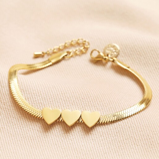 Gold Stainless Steel Three Heart Charm Herringbone Bracelet on Neutral Fabric Gold Stainless Steel Three Heart Charm Herringbone Bracelet