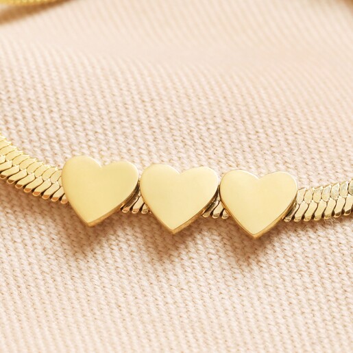 Close Up of Charms Close Up of 3 Flat Heart Charms on Gold Stainless Steel Three Heart Charm Herringbone Bracelet