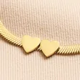 Close Up of Double Hearts on Gold Stainless Steel Two Heart Charm Herringbone Bracelet
