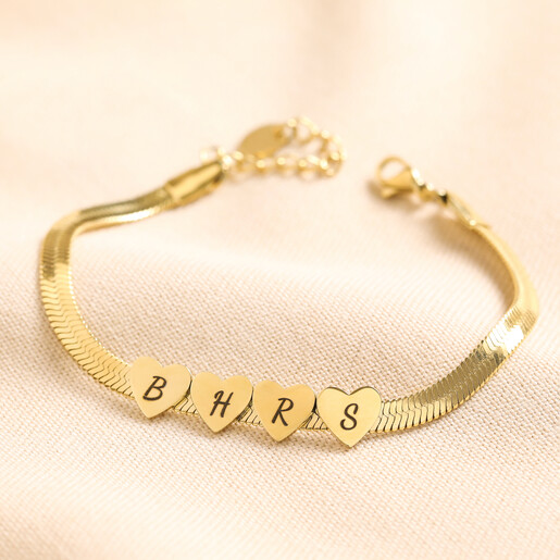 Personalised Gold Stainless Steel Heart Charm Herringbone Bracelet with Four Heart Charms on Beige Fabric 