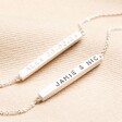 Close Up of Stamping on Personalised Horizontal Bar Bracelet in Silver on Beige Fabric