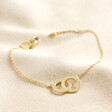 Personalised Interlocking Matte Circles Bracelet in gold on top of beige coloured backdrop