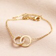 Personalised Interlocking Pearl and Crystal Hoops Bracelet in gold against neutral coloured fabric