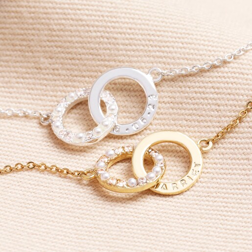 Personalised Interlocking Pearl and Crystal Hoops Bracelets in gold and silver against beige coloured background