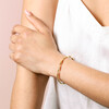 Gold Stainless Steel Twisted Bangle on models arm against beige backdrop