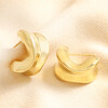 Chunky Organic Hoop Earrings in Gold on top of beige coloured material