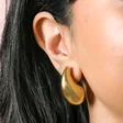 Close up of Gold Stainless Steel Oversized Teardrop Stud Earrings on model
