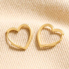 Small Heart Huggie Hoop Earrings in Gold on Beige Fabric