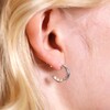 Close up of Encased Pearl Huggie Hoop Earrings in Silver on blonde haired model