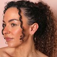 Ridged Huggie Hoop Earrings in Gold on model in front of neutral coloured background