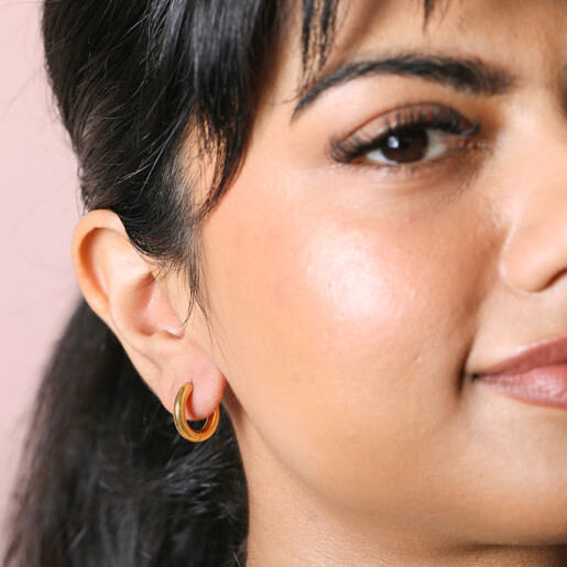 Gold Stainless Steel Huggie Hoop Earrings on model looking forward