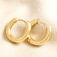 Gold Stainless Steel Huggie Hoop Earrings on top of beige coloured fabric
