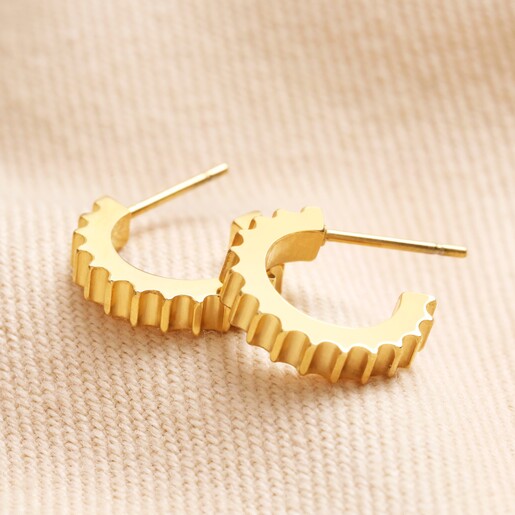 Gold Stainless Steel Ridged Huggie Hoop Earrings on top of beige coloured fabric