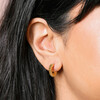 Close up of Gold Stainless Steel Ridged Huggie Hoop Earrings on model