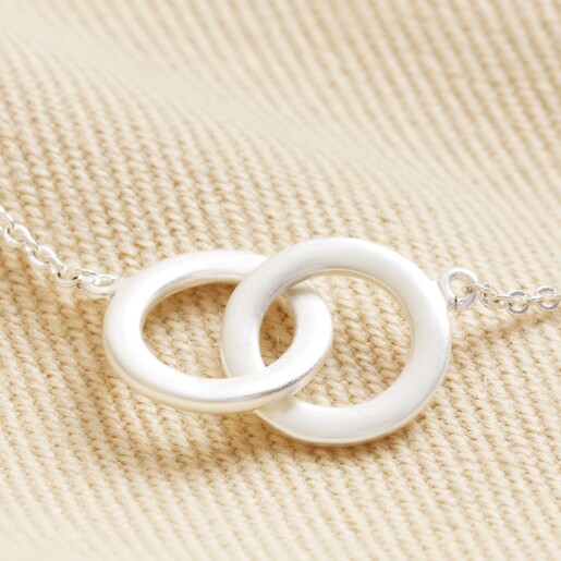 Close up of charm on Interlocking Matte Hoops Bracelet in Silver