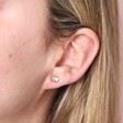 Close Up of Mum and Baby Elephant Stud Earrings in Gold on Model's ear