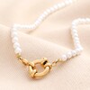 Gold Stainless Steel Pearl Toggle Necklace on Beige Background