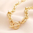 Gold Stainless Steel T-Bar Oval Link Chain Necklace on Beige Background