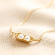 Pearl Two Peas in a Pod Pendant Necklace in Gold on beige fabric