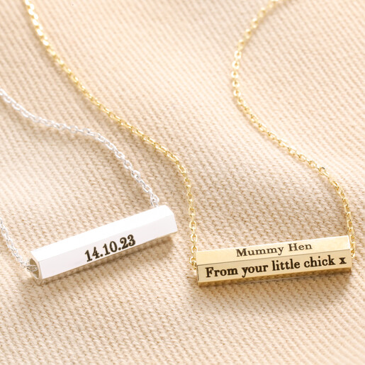 Personalised Hexagonal Barrel Pendant Necklaces in gold and silver on top of beige coloured fabric