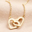 Gold Version of Personalised Interlocking Hearts Necklace on Beige Fabric