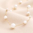 Close up of Stainless Steel Mixed Pearl Necklace in Gold on Beige Background