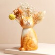 Tigger the Orange Cat Vase with dried flowers inside against beige coloured backdrop