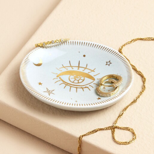 Tiny Blue Celestial Eye Trinket Dish against beige backdrop with earrings inside