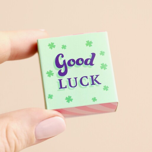 Model Holding Matchbox Model holding Tiny Matchbox Ceramic Clover Token in front of neutral backdrop