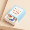 Tiny Matchbox Ceramic Birthday Cake Token with ceramic token poking out of packaging against neutral coloured background