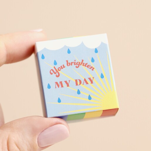 Model holding Tiny Matchbox Ceramic Rainbow Token