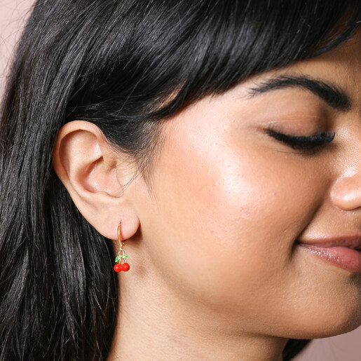 Earrings on Model Model Wearing Enamel Red Cherry Charm Huggie Hoop Earrings in Gold