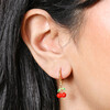 Close Up of Model Wearing Enamel Red Cherry Charm Huggie Hoop Earrings in Gold