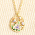 April Enamel Birth Flower Outline Pendant Necklace in Gold against beige material