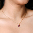 Close Up of Model Wearing Aubergine Pendant Necklace in Gold