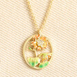 Close up of july Enamel Birth Flower Outline Pendant Necklace in Gold against neutral material
