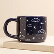 Back of Ceramic Midnight Blue Best Daddy in the Universe Mug against beige backdrop on raised surface