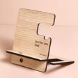 Personalised Engraved Wooden Phone Accessory Stand on Pink Surface