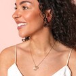 Model smiling wearing Personalised Crescent Moon Disc Pendant Necklace against beige background