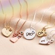 Group Shot of Personalised Pride Symbol and Colourful Crystal Charm Necklace on Beige Background with Rainbow Shaddow