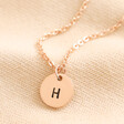 Personalised Sterling Silver Initial Disc Charm Necklace in rose gold against beige fabric