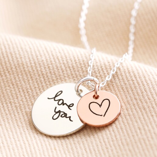 Personalised 'Your Drawing' Double Disc Charm Necklace Large silver disc charm and small rose gold charm on Personalised 'Your Drawing' Double Disc Charm Necklace against beige background