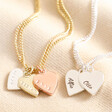 Close up of pendants on Personalised Mixed Metal Heart Bracelet against beige background